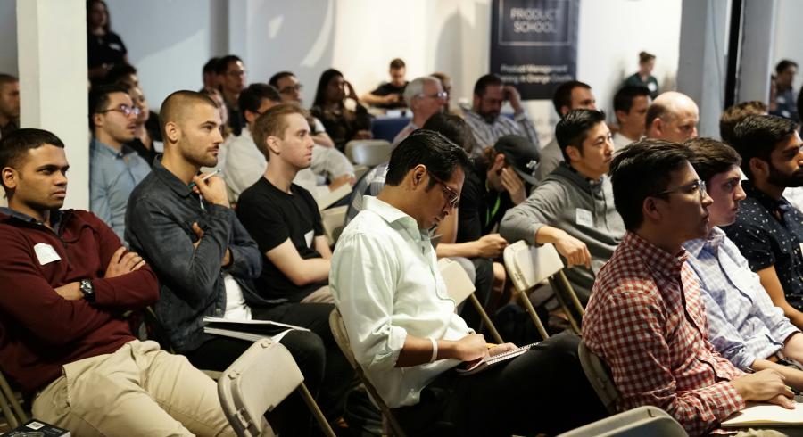 Employees at a company-wide staff meeting in a large hall